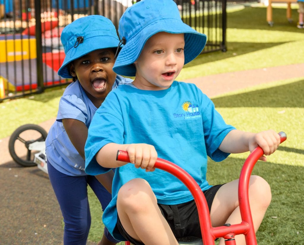 two children playing outside on bike