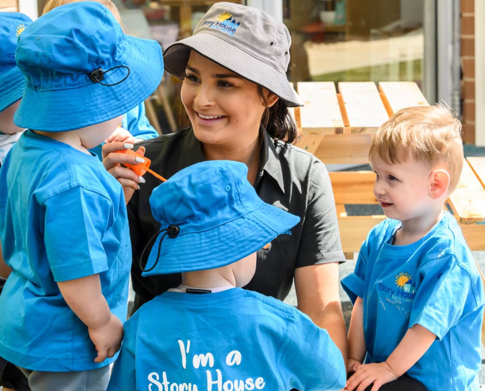 childcare worker blowing bubbles with children