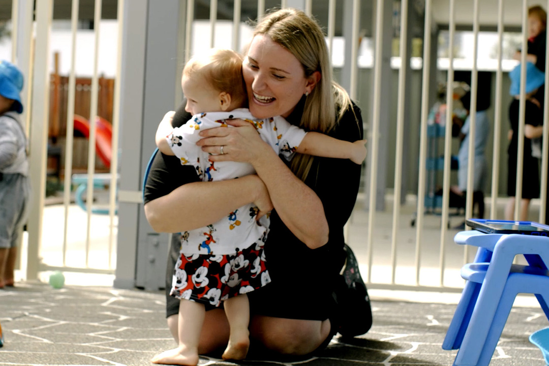 Childcare instructor hugging child to demonstrate effective communication skills