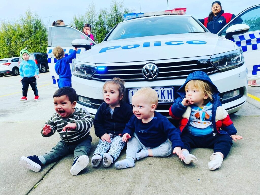 Children sitting in front of a Police car in Geelong