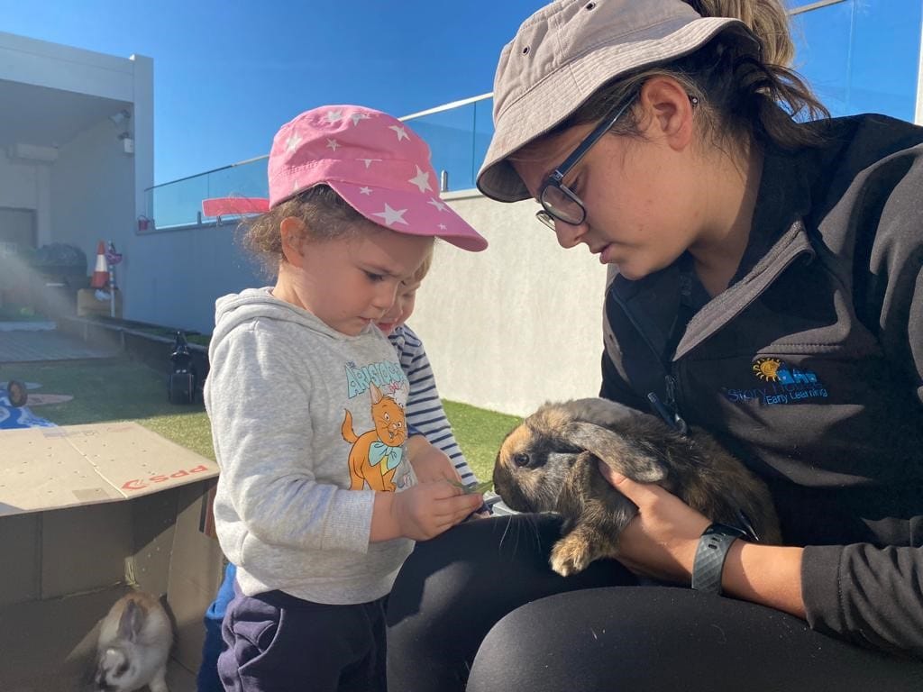 Children feeding a bunny at Story House Miranda