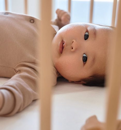 Newborn lying on his bed at home